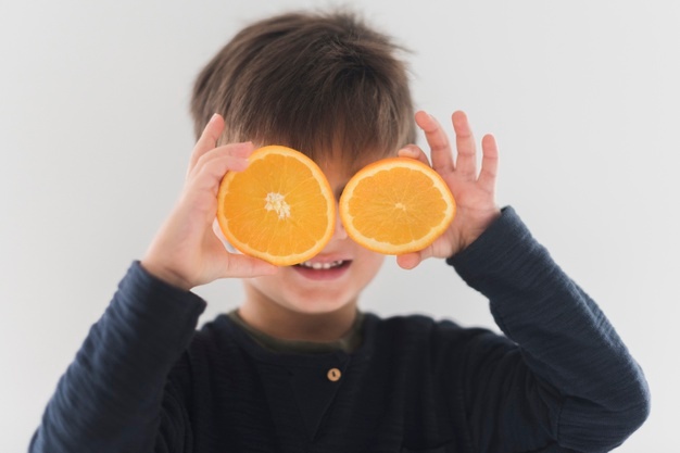 retrato-nino-mitades-naranjas-sobre-ojos